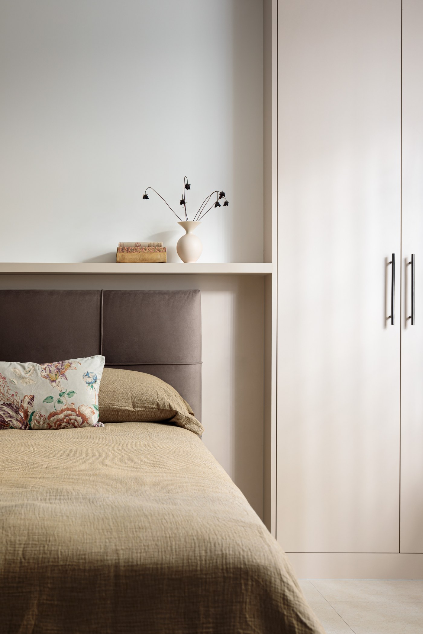 Bedroom at Brompton Square with full-height fitted wardrobes and upholstered headboard