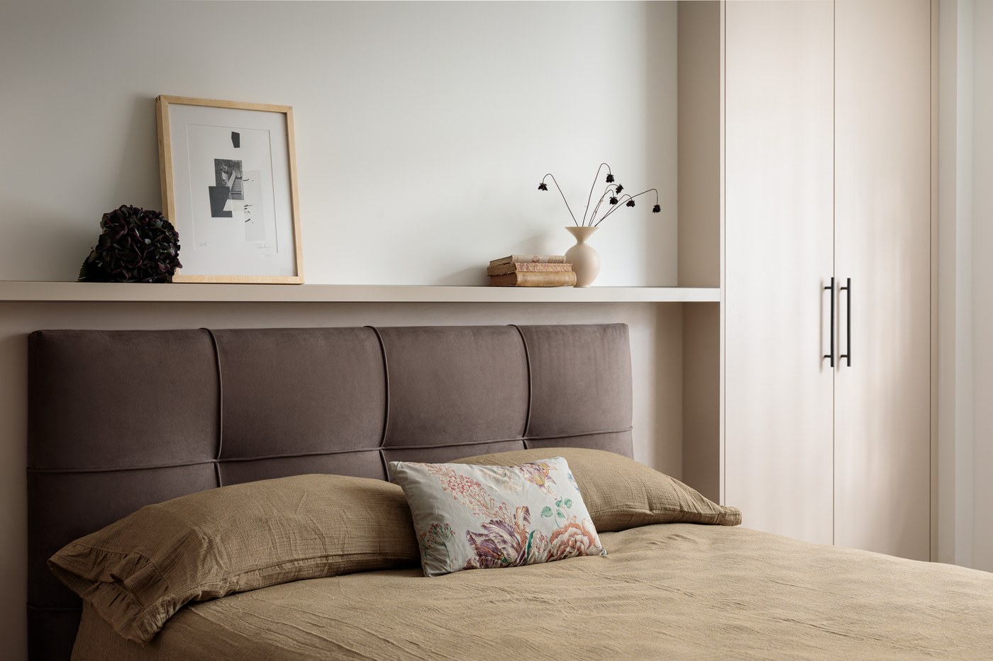 Principal bedroom at Brompton Square with a fitted joinery headboard wall and recessed shelf