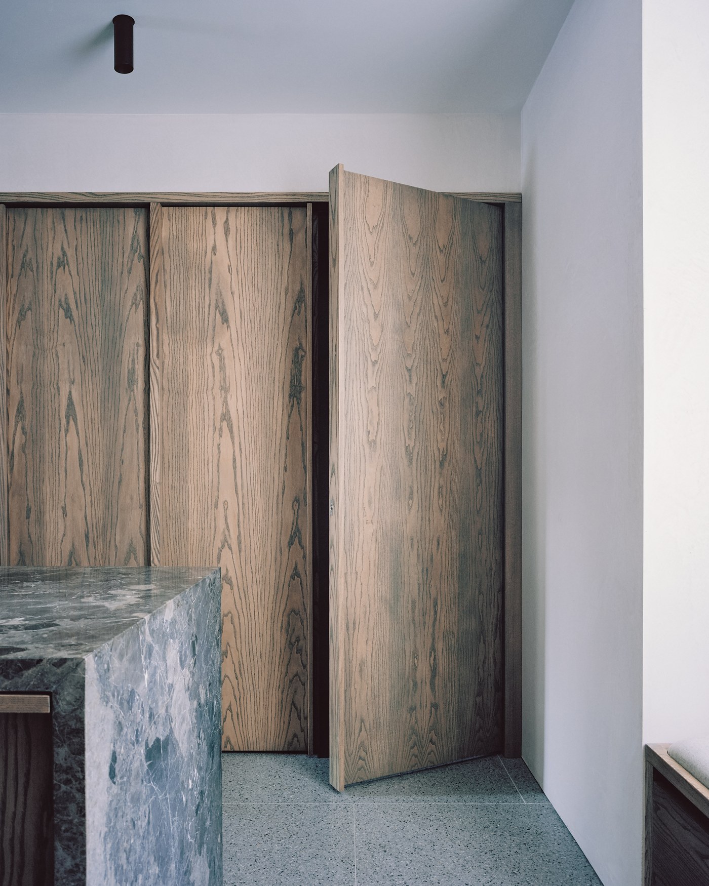 Caithness Road W14 — full-height flush ash doors, one open, beside the stone kitchen island