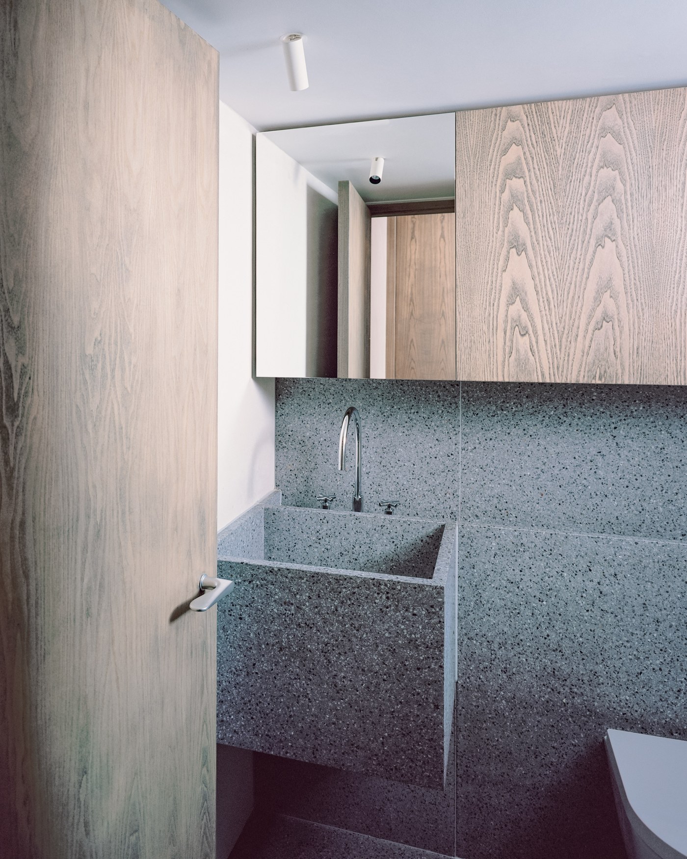Caithness Road W14 — bathroom with a speckled stone basin and walls, and a flush ash door