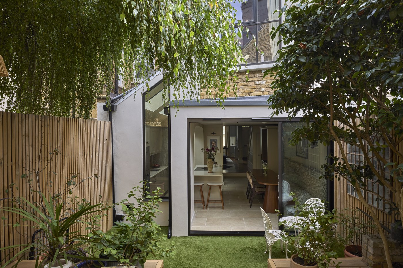 Honeywell Road SW11 — the rear extension from the garden, with its glazed side return, rendered walls and full-width sliding doors