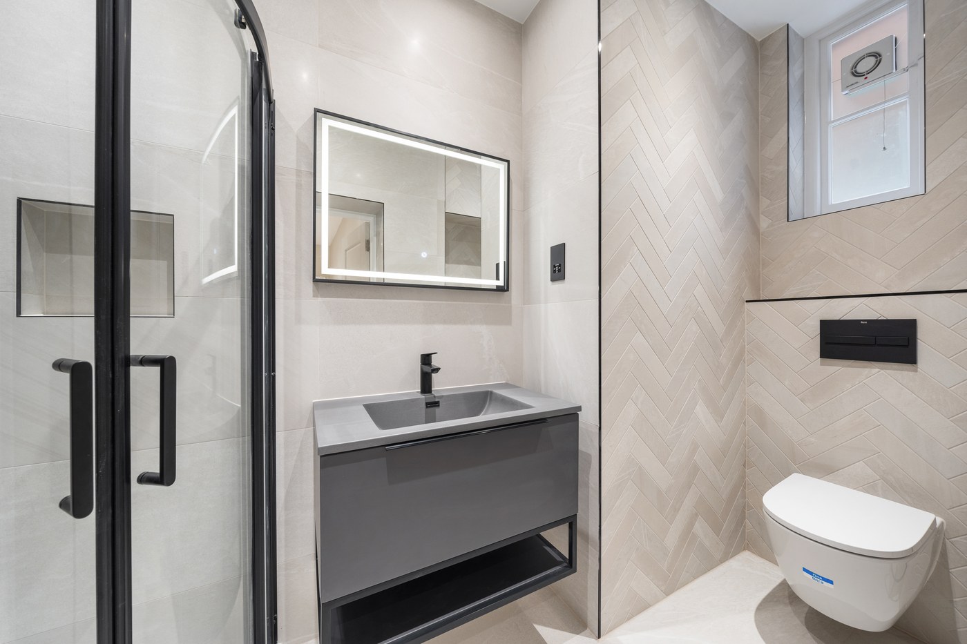 Shower room at St John's Wood Road with herringbone wall tiling and a fitted vanity